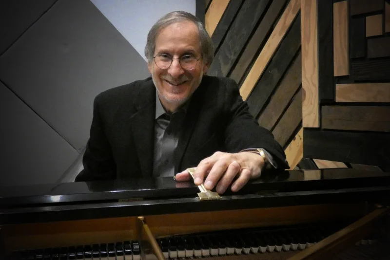 A photo of David Janeway by his piano.